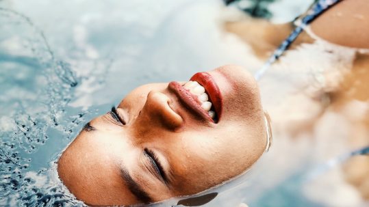 woman with healthy skin floating in water