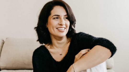 woman with healthy ageing skin sitting in her living room
